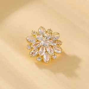 Macro shot of gold floral brooch with micro-pave cubic zirconia and marquise-cut stones