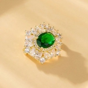 Macro top view of gold ring featuring an oval green zircon and marquise-cut accents