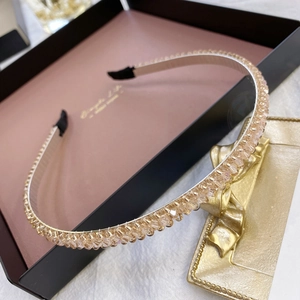Detail of crystal beaded headband in champagne gold color placed in a gift box