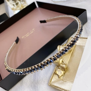 Macro detail of elegant golden metal headband with dark blue and champagne crystal beads