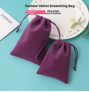 Detail of purple velvet drawstring pouches with dual cords in an elegant still life setting