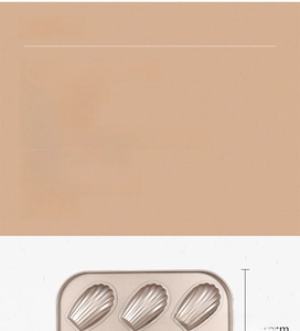 Detail of 6-cavity gold carbon steel Madeleine pan showing shell-shaped molds and size
