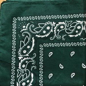 Close-up of dark green cotton paisley bandana showing fabric texture and stitched edges