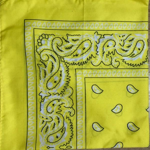 Detail of yellow paisley bandana fabric showing intricate black and white patterns