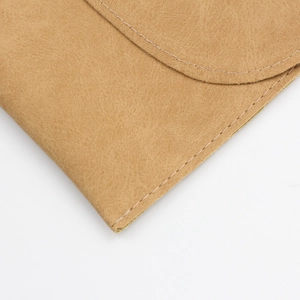 Close-up detail of the brown faux suede makeup brush bag showing high-quality stitching