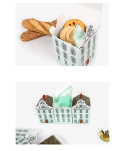 Detail of house-shaped gift boxes in light teal with charming black and white illustrations