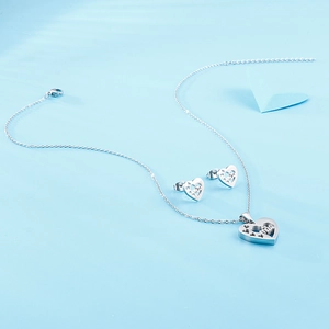 Ensemble élégant collier et boucles d'oreilles cœur argenté avec motifs ajourés