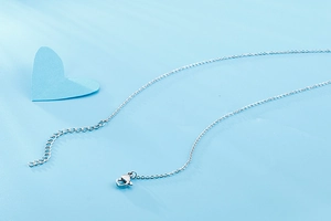Detailed view of silver necklace chain featuring a secure lobster clasp and extender link