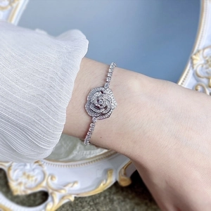 Macro view of silver camellia bracelet with sparkling zircons on a model wrist