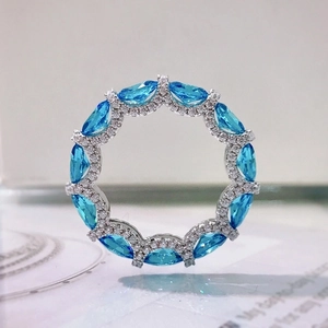 Macro shot of silver ring pendant with marquise blue stone and clear pavé crystals