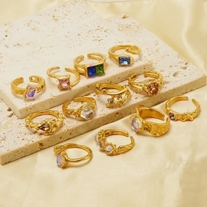 Detailed close-up of retro gold-plated adjustable rings with colorful gemstones on silk