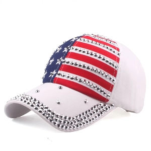 Detailed view of white baseball cap featuring US flag prints and silver conical metal studs