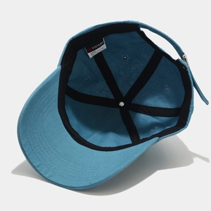 Detailed interior of blue cotton baseball cap showing six-panel stitching and metal buckle
