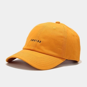 Close-up of CRUISE embroidery and reinforced stitching on orange baseball cap