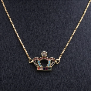 Macro shot of crown pendant with colorful zircons on a gold-plated box chain
