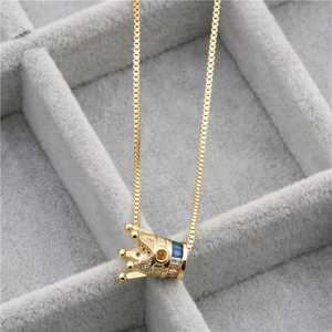 Close-up of golden crown necklace with colorful zircons in a gray velvet jewelry box