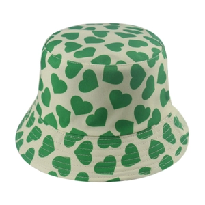 Close-up detail of green heart pattern on cream bucket hat with reinforced stitching