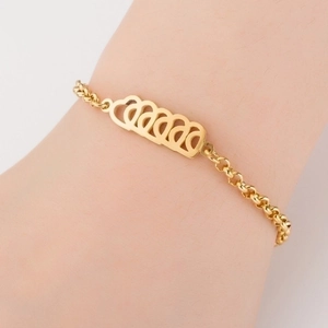 Detail of a gold titanium steel bracelet featuring hollow heart charms on a female wrist