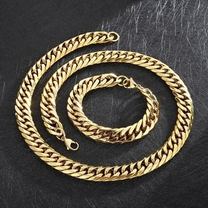 Polished gold stainless steel Cuban link necklace and bracelet set on black background