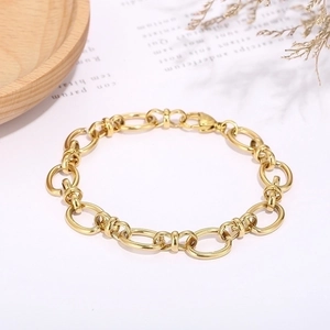 Detail of golden geometric knot link bracelet featuring a classic lobster clasp closure