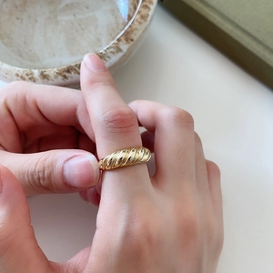 Detail of 925 silver croissant dome ring in gold finish worn on the index finger