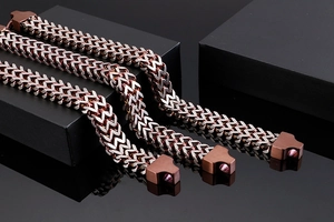 Detail of two-tone braided stainless steel link chains on minimalist black display blocks