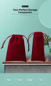 Macro detail of burgundy velvet jewelry pouches with drawstrings in two sizes on wood surface