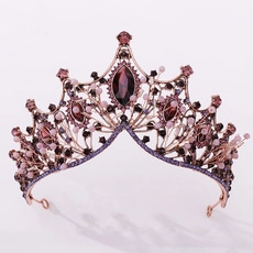 Macro shot of vintage crown with deep red gemstones and pink beads on metal base