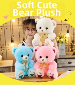 Detail of plush teddy bears in white, blue, and pink with decorative ribbon and foot embroidery