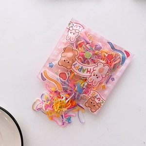 Macro view of macaron colored elastic hair ties in cute cartoon bear packaging