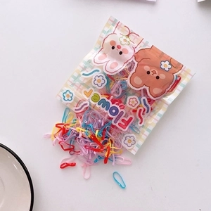 Close-up of colorful elastic hair bands spilling from a cute cartoon zipper pouch