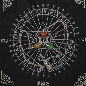 Detailed view of three natural stone pendulum necklaces on a mystical divination mat