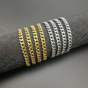 Gold and silver 5mm Cuban link necklaces in various thicknesses on a dark display stand