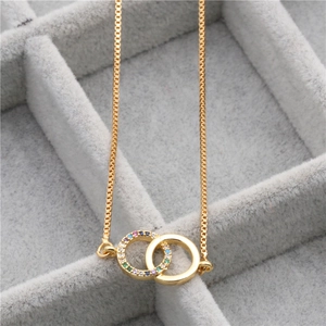 Golden micro-paved zircon double ring pendant necklace on a premium gray velvet box