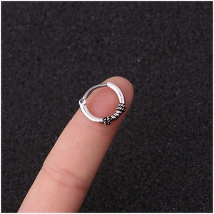 Vintage silver stainless steel hoop ring with textured twist design on a fingertip
