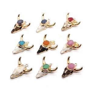 Detail view of nine acrylic bull head pendants with gold trim and multi-color rhinestones