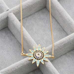 Close-up of a gold box chain bracelet with a blue zircon celestial evil eye sun pendant
