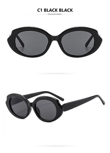 Detail of vintage cat-eye sunglasses featuring a glossy black frame with wavy edges