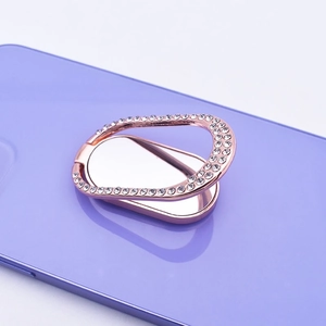 Close-up of rose gold oval phone ring holder with rhinestones on a purple phone