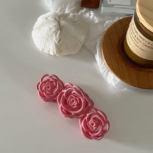 Close-up of pink matte rose flower hair claw clip in a French romantic lifestyle setting