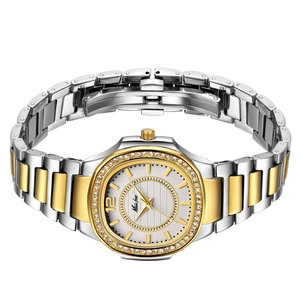 Close-up of gold and silver two-tone ladies watch with diamond bezel and metal strap