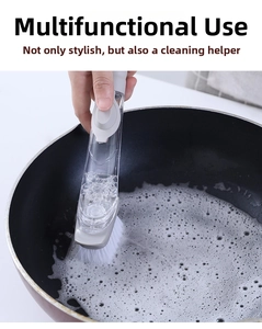 Close-up of long handle kitchen dish brush with liquid soap dispenser cleaning a pot