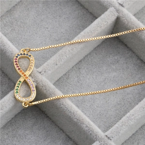 Detailed close-up of infinity pendant with rainbow cubic zirconia and gold box chain