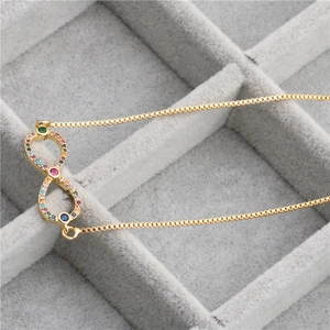 Detail of a gold infinity bracelet with multi-colored crystals in a jewelry box