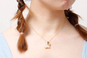 Close-up of golden reindeer antler necklace with sparkling zircon on model's neck