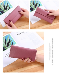 Close-up of litchi texture on purple soft leather long wallet being held by hand