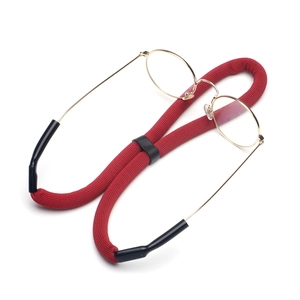 Red braided floating sport eyewear strap with anti-slip rubber loops on gold glasses