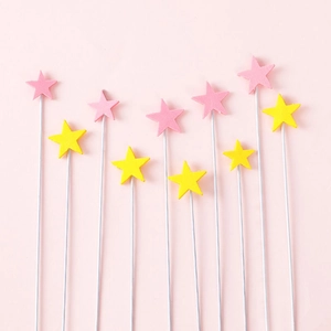 Detailed view of ten colorful EVA foam star cake toppers in soft pink and yellow