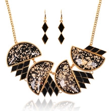 Detailansicht des klobigen Goldschmuck-Sets mit schwarzem Harz und Blattgold-Dekor