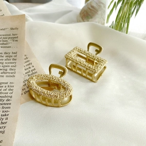 Retro gold metal hair claws with embossed rose patterns in oval and rectangular shapes
